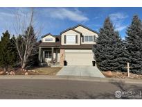 Two-story house with beige siding, attached garage, and landscaping at 1937 Reliance Cir, Superior, CO 80027