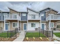 Modern two-story townhome with attached balcony and fenced front yard at 2822 South Flat Cir, Longmont, CO 80503