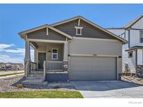 Craftsman style home with gray siding, a two-car garage, and a covered front porch at 2957 South Flat Cir, Longmont, CO 80503