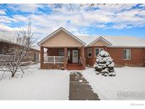 Brick ranch home with a covered porch, freshly fallen snow on the ground at 302 Victoria St, Berthoud, CO 80513