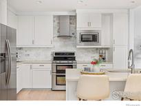 Modern kitchen with stainless steel appliances and white cabinetry at 3301 Arapahoe Ave # 225, Boulder, CO 80303