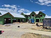 New construction project with green sheathing and a beautiful blue sky backdrop at 3379 Danzante Bay Ct, Berthoud, CO 80513