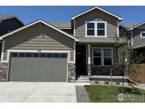Beautiful two-story home featuring stone accents and a gray garage door at 793 Griffith St, Lochbuie, CO 80603