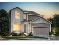 Two-story home with gray siding, two-car garage, and landscaping at 795 Griffith St, Lochbuie, CO 80603