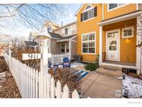 Inviting two-story home with a charming front patio and white picket fence at 911 Snowberry St, Longmont, CO 80503