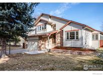 Two-story house with stone accents and a landscaped yard at 1830 Tyler Ave, Louisville, CO 80027