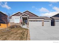 Two-story house with stone accents and a three-car garage at 2163 Chianina St, Mead, CO 80542