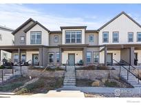 Modern townhome with gray siding, front porch, and landscaping at 616 Discovery Pkwy, Superior, CO 80027