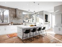 Modern kitchen with white cabinets, island, and large window at 635 Arapahoe Ave # A, Boulder, CO 80302