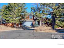 Two-story house with wood siding, attached garage, and mature trees at 649 W Birch Ct, Louisville, CO 80027