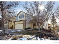 Two-story house with light beige siding, attached garage, and landscaping at 6646 Bean Mountain Ln, Boulder, CO 80301