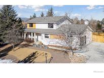 Inviting two-story home featuring a charming front porch, manicured lawn and attractive landscaping at 6969 Harvest Rd, Boulder, CO 80301