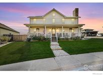 Two-story farmhouse with front porch and landscaped lawn at 934 Larkspur Ln, Louisville, CO 80027