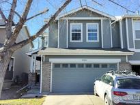 Two-story house with gray siding, attached garage, and landscaping at 9389 Garfield St, Thornton, CO 80229