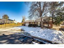 Brick ranch house with attached garage and fenced yard at 1011 Yeager Dr, Longmont, CO 80501