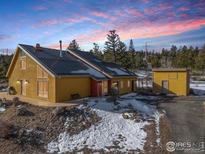 A stunning contemporary home with a metal roof and solar panels, nestled on a mountainside at 1335 Deer Trail Rd, Boulder, CO 80302