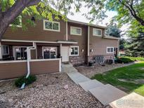 Attractive brown townhouse exterior with a walkway and landscaping at 1601 Great Western Dr # A7, Longmont, CO 80501