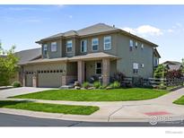 Two-story house with green siding, brick accents, and a landscaped yard at 20356 E Shady Ridge Rd, Parker, CO 80134