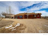 Ranch style home with log siding, detached garage, and spacious yard at 2244 County Road 12, Erie, CO 80516