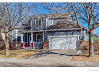 Two-story home with gray siding, red accents, and a two-car garage at 614 Americana Rd, Longmont, CO 80504