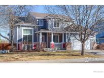 Two-story house featuring gray siding, red accents, and a two-car garage at 614 Americana Rd, Longmont, CO 80504