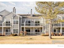 Exterior view of a light gray townhouse with a balcony and green lawn at 7431 Singing Hills Dr # 7431, Boulder, CO 80301