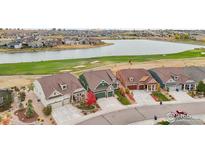 Community overview featuring houses, lake, and golf course at 8027 Tamarac Ct, Thornton, CO 80602