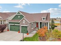 Two-story house with green and stone accents, two-car garage, and landscaping at 8027 Tamarac Ct, Thornton, CO 80602