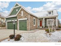 Charming home with a stone facade, three-car green garage doors, and a well-manicured lawn with light snow at 8027 Tamarac Ct, Thornton, CO 80602