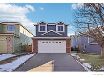 Two-story home with brick and gray siding, white garage door, and a small front yard at 11562 Depew Ct, Westminster, CO 80020