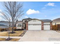 Ranch style home with two-car garage and landscaped yard at 1434 Hickory Dr, Erie, CO 80516