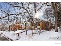 Snow-covered two-story home with a gray and yellow exterior and porch at 1520 Baseline Rd, Boulder, CO 80302