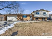 Ranch style home with attached garage and landscaped yard at 1537 Hilltop Dr, Longmont, CO 80504