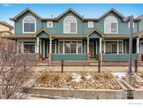 Green townhome exterior with brick accents and a welcoming front porch at 2855 Rock Creek Cir # 257, Superior, CO 80027