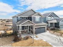 Two-story house with gray siding, stone accents, and a two-car garage at 344 Ellie Way, Berthoud, CO 80513