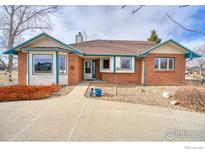 Brick ranch home with landscaped yard and attached two-car garage at 4135 Surrey Ct, Lafayette, CO 80026