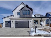 Two-story modern farmhouse with gray and white exterior, stone accents, and a three-car garage at 497 Muirfield Cir, Louisville, CO 80027