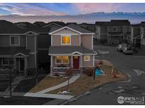 Two-story house with red door, light brown siding, and a small porch at 6108 Summit Peak Ct # 102, Frederick, CO 80516