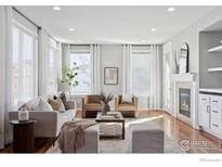 Bright living room features hardwood floors, a fireplace, and ample natural light at 10054 Telluride St, Commerce City, CO 80022