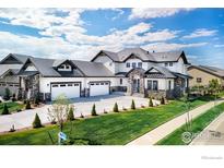 Stunning two-story home showcasing a three-car garage and meticulously landscaped front yard on a sunny day at 2294 Stonebrae Ct, Berthoud, CO 80513