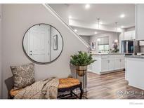 Bright entryway with bench, mirror, and view into kitchen at 2736 Cooperland Blvd, Berthoud, CO 80513