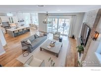 Open concept living room showcasing a kitchen, hardwood floors, and access to a patio at 3681 Paonia St, Boulder, CO 80301