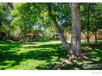 Large backyard with lush lawn, mature trees, patio, and shed at 3776 Orange Ln, Boulder, CO 80304