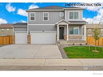 Two-story house with gray siding, two-car garage, and front porch at 4207 Sandstone Dr, Mead, CO 80504