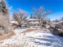 Spacious backyard with large trees and snowy ground at 4667 Ashfield Dr, Boulder, CO 80301