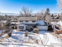 Two-story house with attached garage, snowy yard, and mountain views at 4667 Ashfield Dr, Boulder, CO 80301