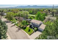 Charming two-story home with a well-maintained lawn, mature trees, and mountain views at 4667 Ashfield Dr, Boulder, CO 80301