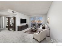 Bright living room with balcony access and modern furniture at 5110 Williams Fork Trl # 203, Boulder, CO 80301