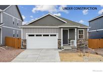 Newly constructed ranch-style home with gray siding and a two-car garage at 827 Ledge St, Lochbuie, CO 80603