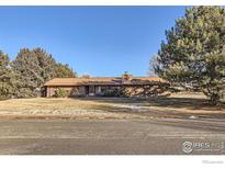 Ranch style home with brick exterior and mature landscaping at 8847 Quail Rd, Longmont, CO 80503